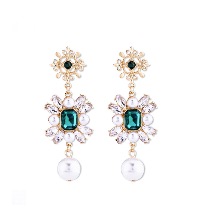 A pair of vintage-style gold-tone floral dangle earrings featuring a prominent emerald green gemstone, surrounded by white faux pearls and clear crystals.