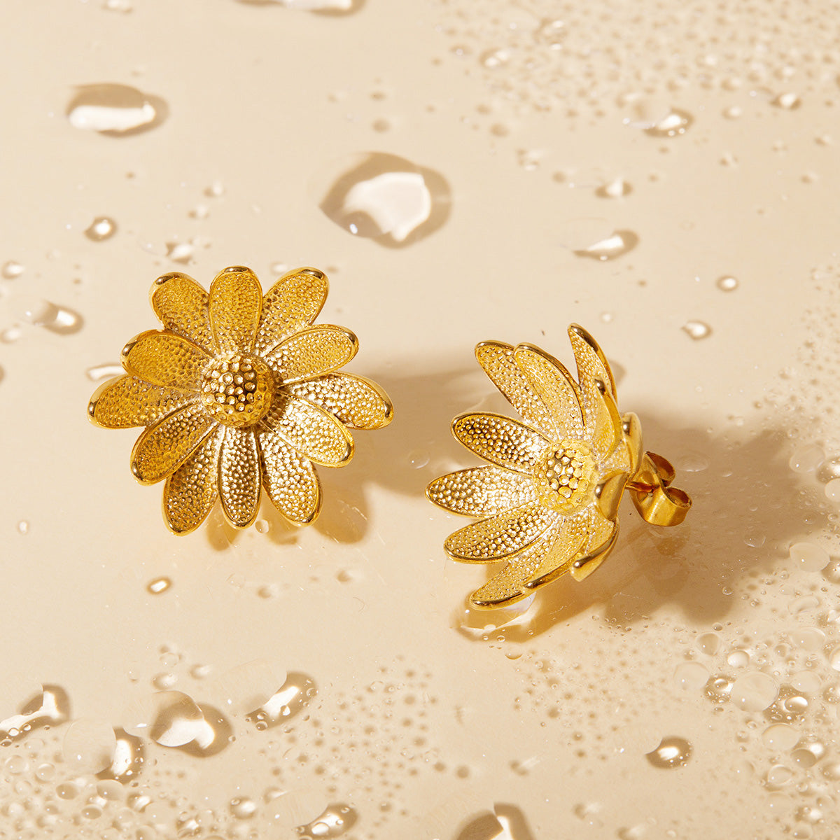 A pair of stainless steel stud earrings shaped like 3D sunflowers with a detailed, textured gold finish, shown on a plain background.