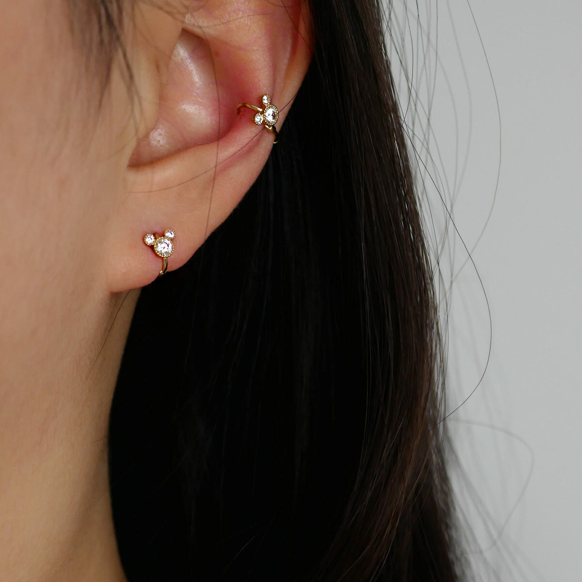 A model wears the 925 sterling silver huggie hoop earrings, highlighting the brilliant sparkle of the CZ stones and the comfortable, close-fitting design.