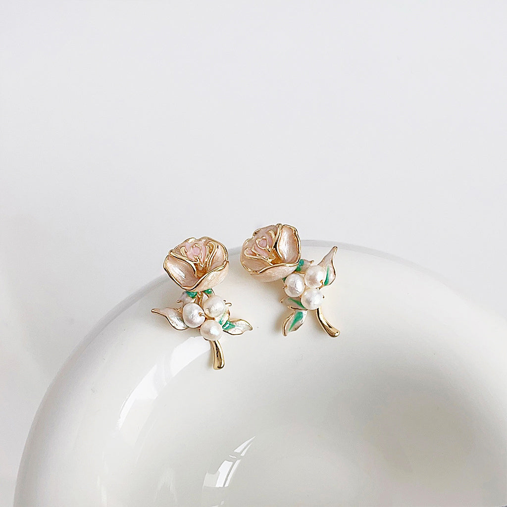 A set of five pairs of vintage-style 14k gold-plated rose flower stud earrings with delicate enamel, pearl details, and green leaves.