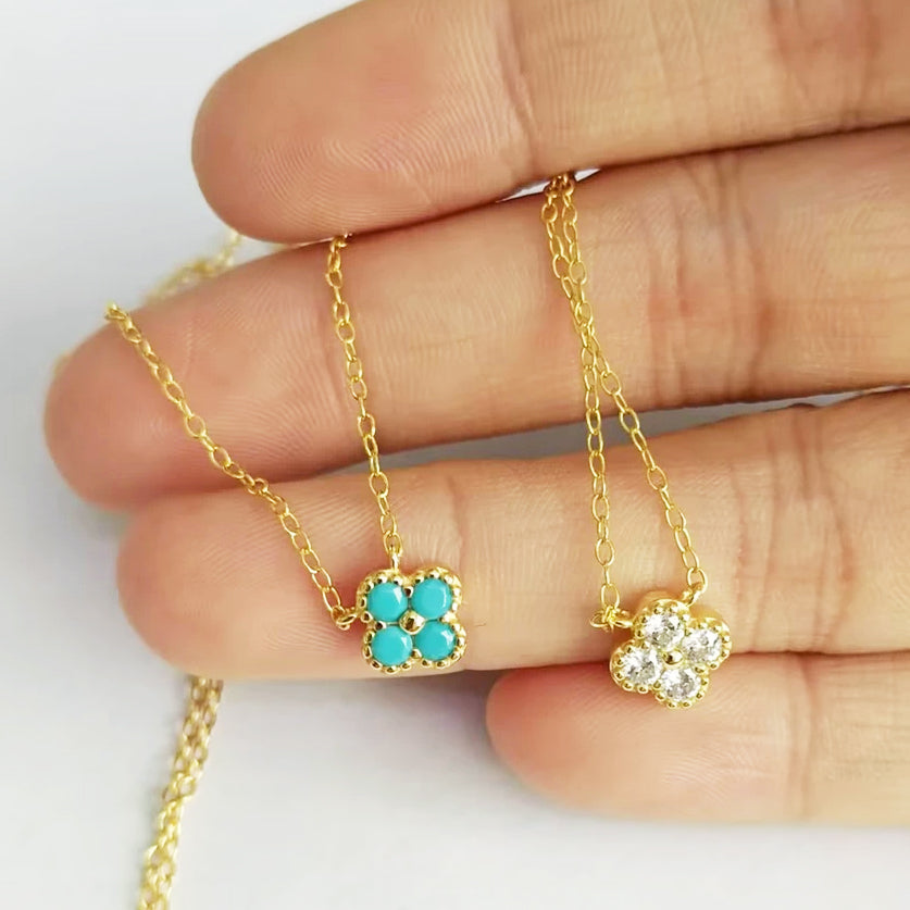 A set of 925 sterling silver necklaces with delicate flower pendants, featuring both turquoise and clear zircon options.