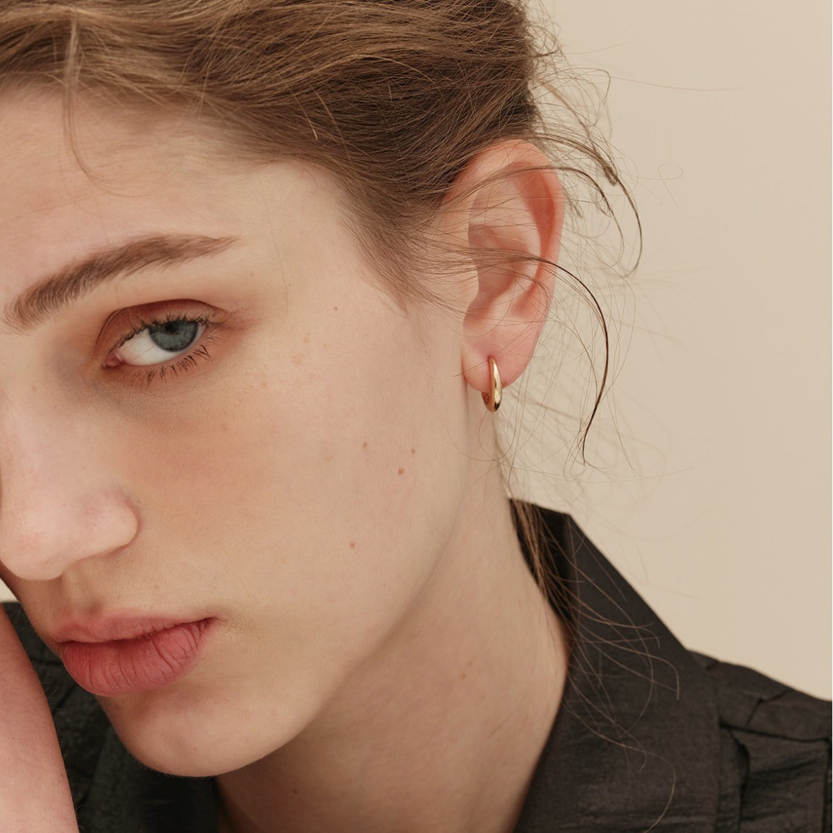 Close-up portrait of a model wearing the 925 Sterling Silver 18K Gold Plated Hoop Earring, showcasing its elegant design and shine.