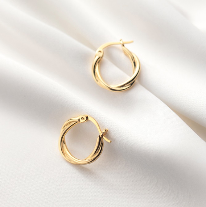 A pair of elegant 925 Sterling Silver Twisted Plain Hoop Earrings with a gold finish, resting on a white satin background to highlight their lustrous shine.