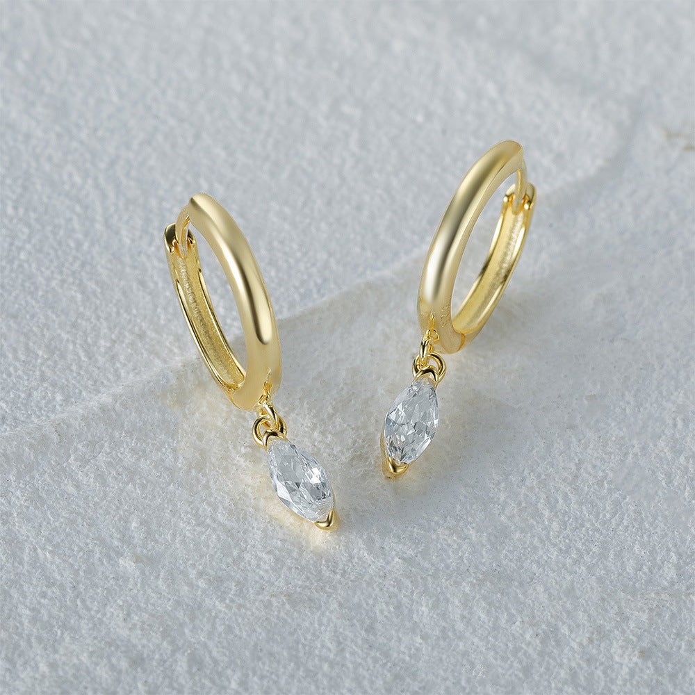 Close-up of 925 sterling silver drop earrings with a gold finish, showcasing shimmering white marquise-cut cubic zirconia stones.