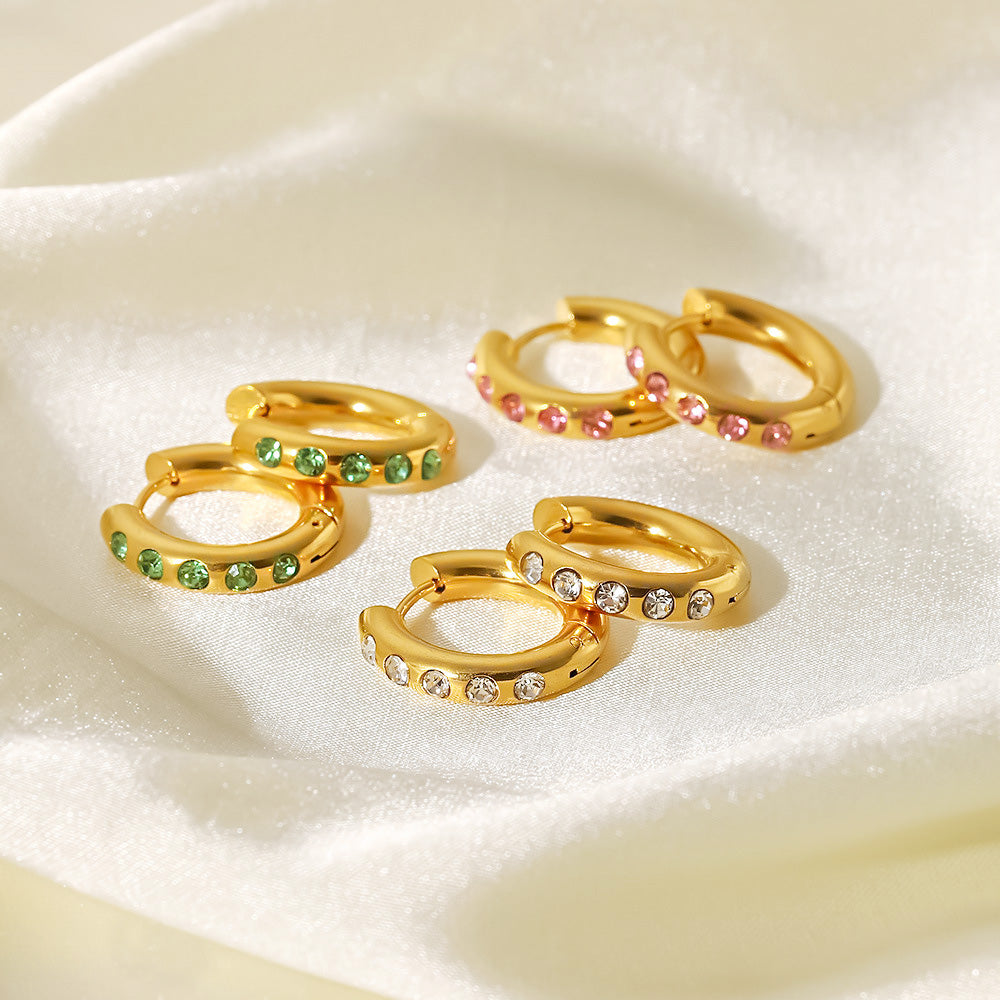 A collection of gold-plated stainless steel hoop earrings featuring vibrant green, pink, and white cubic zirconia gemstones, displayed on a clean white background.