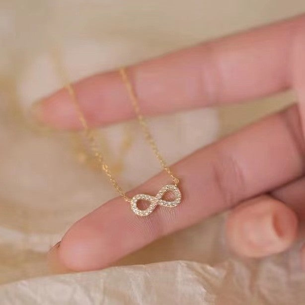 A close-up of the elegant 925 sterling silver infinity pendant necklace in a radiant gold finish, showcasing the sparkling cubic zirconia stones.