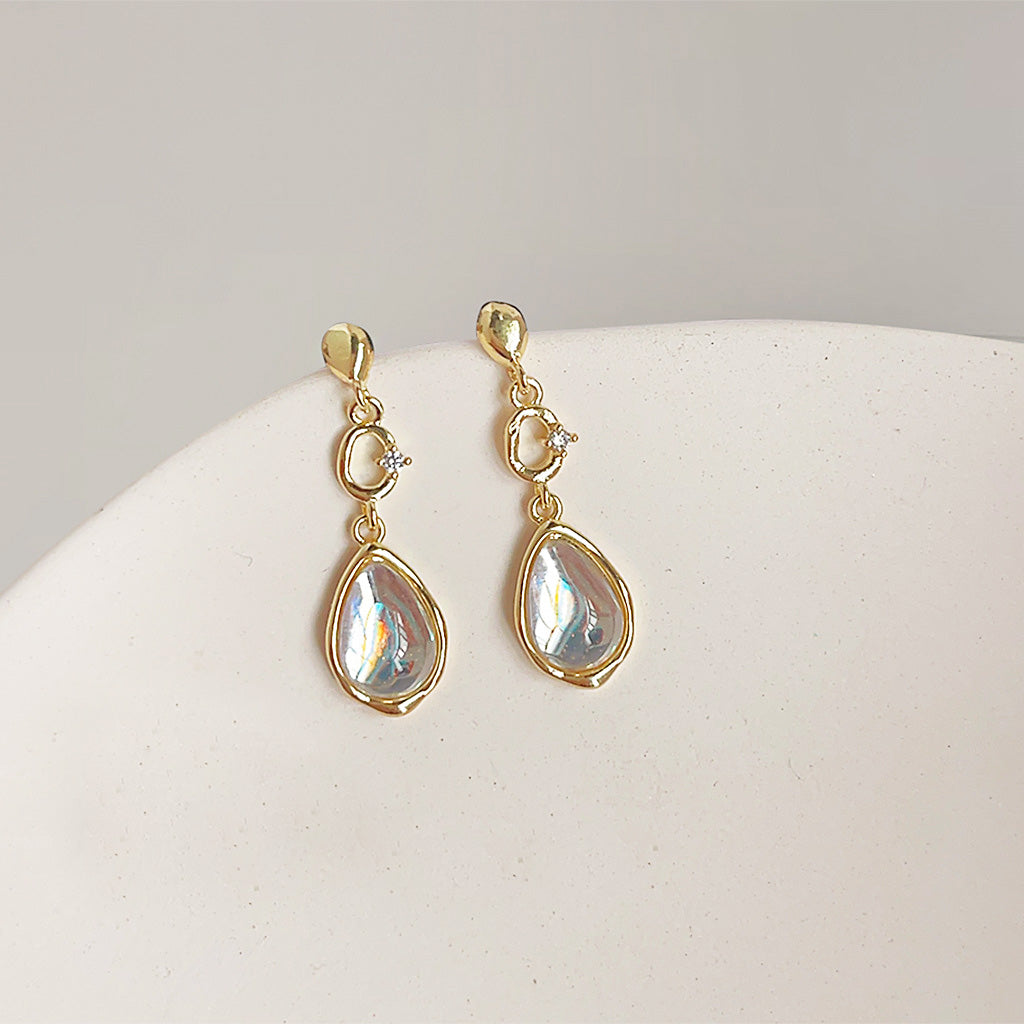 A pair of 14k gold plated water drop earrings with iridescent clear glass teardrop stones on a white background.