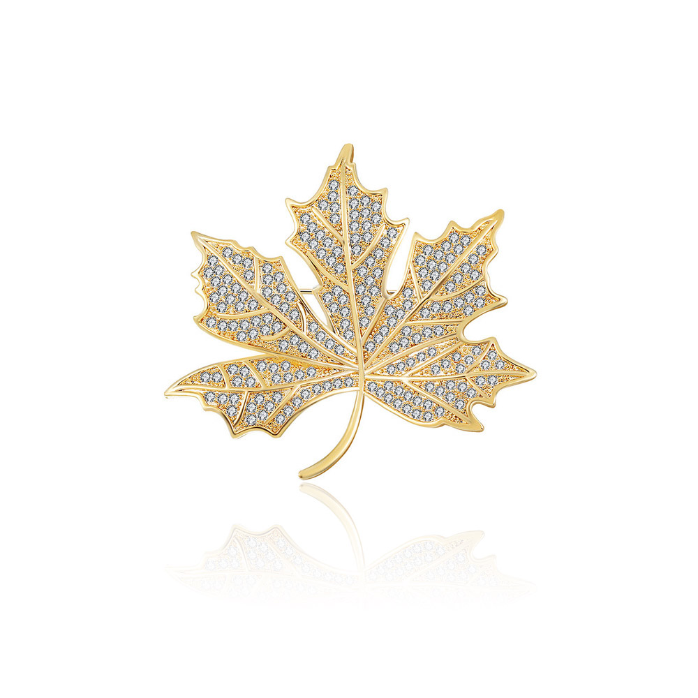 A close-up of the Gold Plated Maple Leaf Brooch, showcasing its detailed design and sparkling white cubic zirconia stones on a brass base.