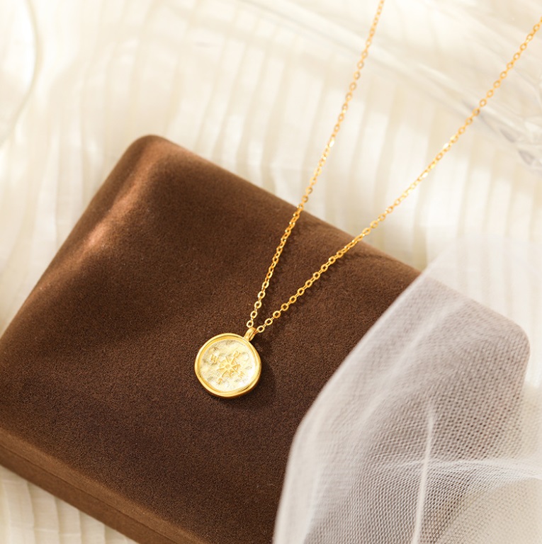 A beautiful 925 Sterling Silver Compass Necklace with a gold finish, displayed elegantly in a brown velvet jewelry box.