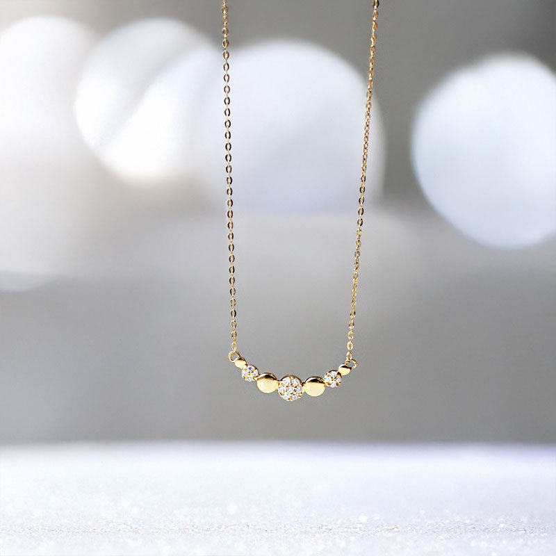 Close-up of a 925 sterling silver necklace with 18k gold plating, featuring an elegant curved smile disc pendant.