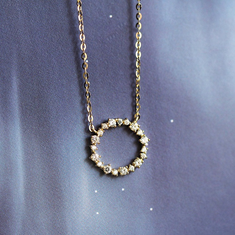 A close-up of the 925 sterling silver zircon wreath pendant necklace, highlighting the sparkling stones set in a circular design.