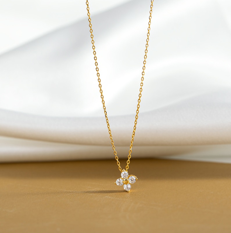 A stunning 925 Sterling Silver Leaf Clover Necklace in a gold finish, featuring a four-leaf clover pendant set with brilliant white cubic zirconia stones.