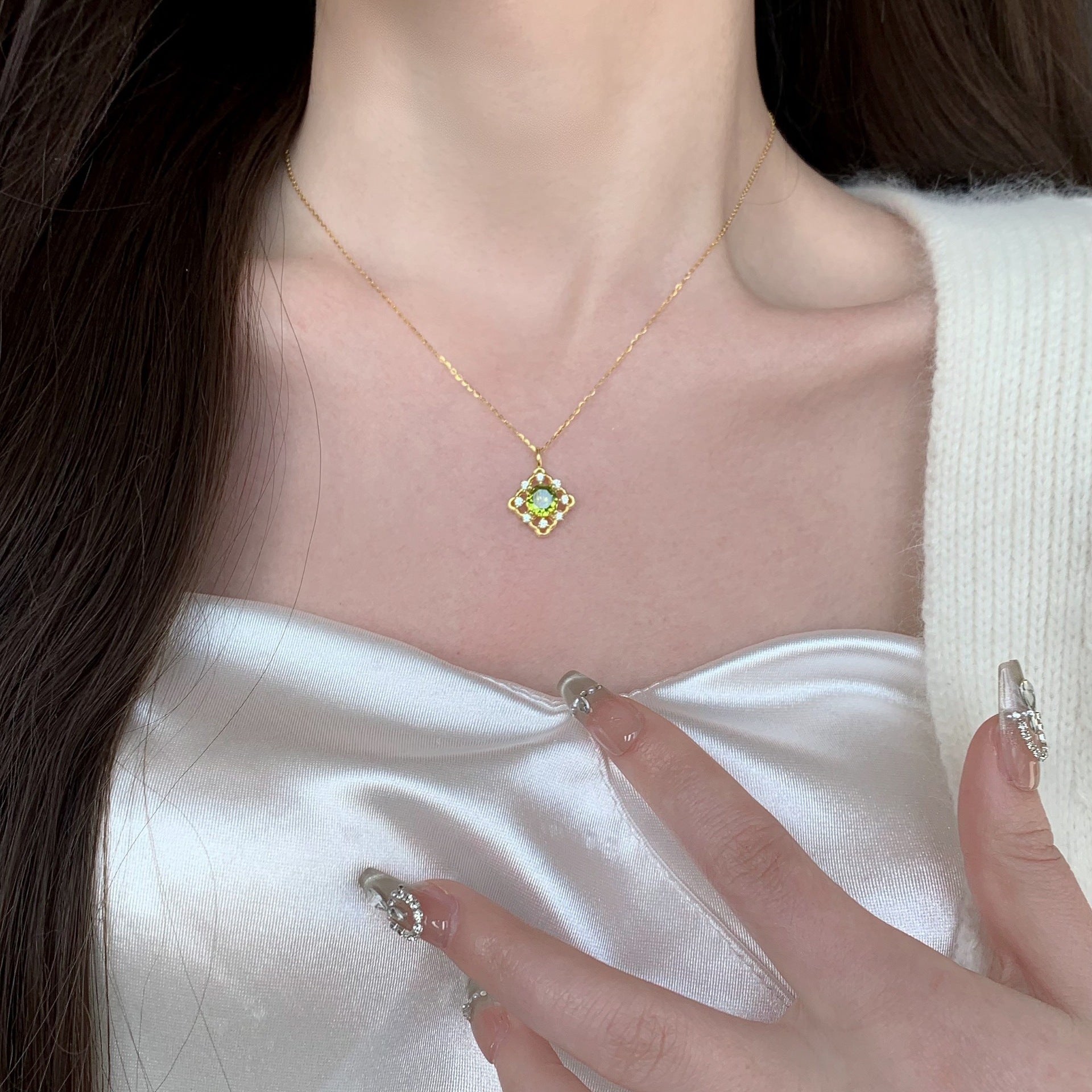 A close-up of the 925 Sterling Silver 14K Gold Plated Green Zircon Pendant Necklace, showcasing the vibrant green stone and delicate gold chain.