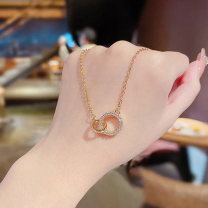 A detailed close-up of the 925 Sterling Silver Zircon Double-Circle Pendant Choker Necklace, highlighting the interlocking gold rings with sparkling zircon accents.