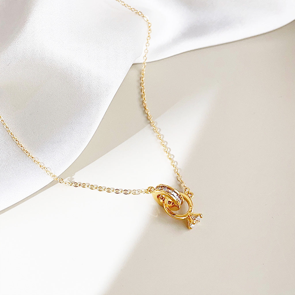 A close-up of the elegant gold-plated zircon interlock circle and rings necklace on a clean white background, showcasing the sparkling stones.