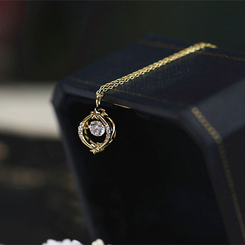 A close-up of the 925 sterling silver dancing star hollow zircon necklace, showing the intricate gold pendant with a central gemstone and star motifs.