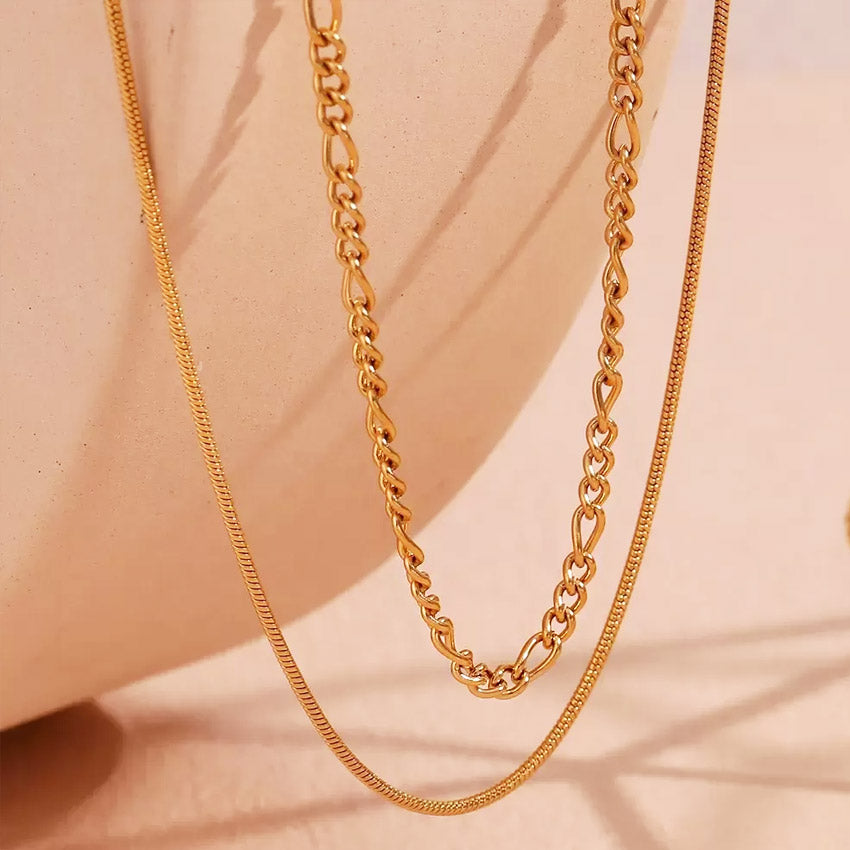 Detailed view of the double collar layered stainless steel necklace, showcasing the distinct Figaro and snake chain designs plated in 18k gold.