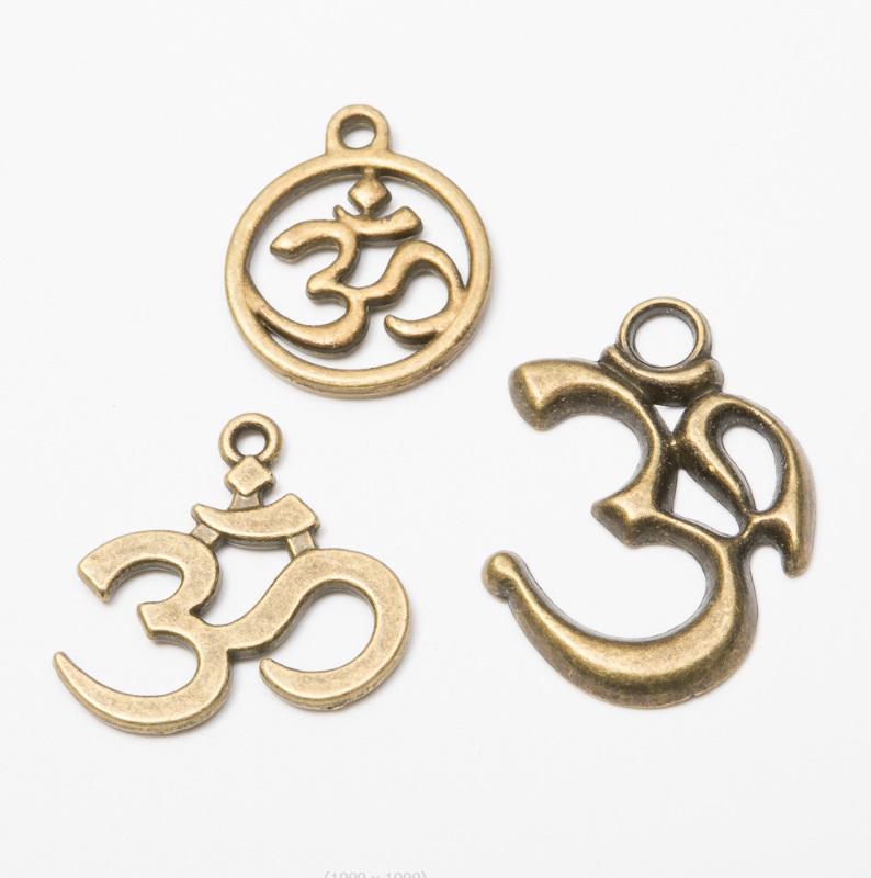 A close-up of three custom gold OM pendant charms, showcasing the intricate design and polished finish offered by JR Fashion Accessories.