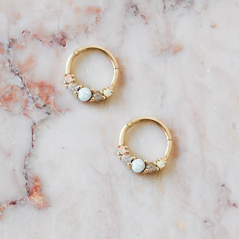 A close-up studio shot of a pair of gold-plated 925 sterling silver hoop earrings adorned with a central opal and small accent diamonds.