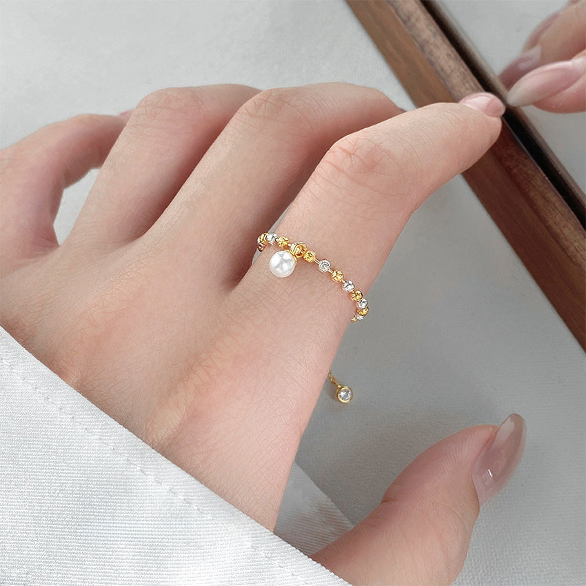 A close-up of the wholesale 925 sterling silver two-tone beaded pearl adjustable ring worn on a finger, showcasing its intricate Italian-cut detailing.