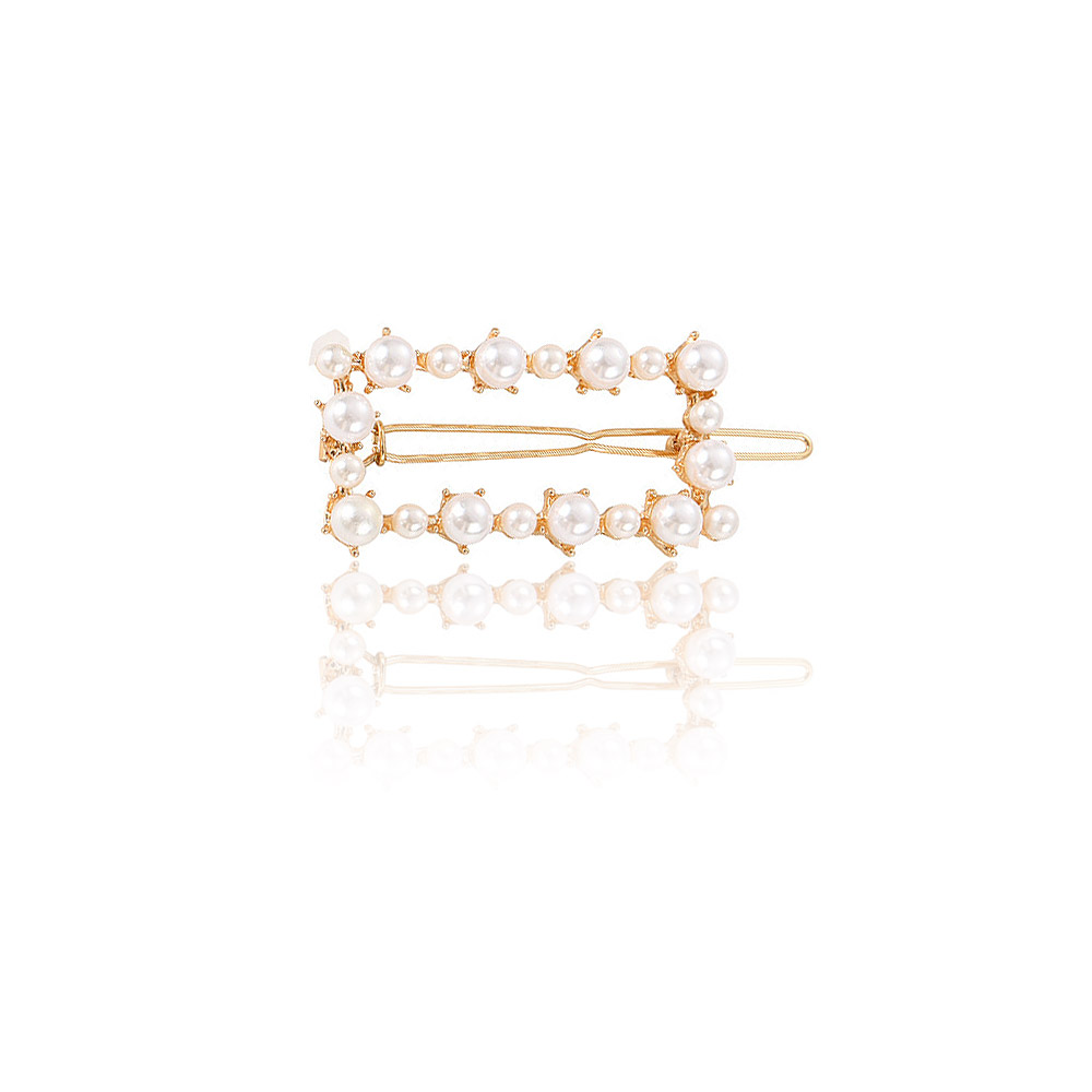A close-up of the minimalist women's hair clip (JRA-003), featuring a lustrous pearl set on a polished gold-plated clip.