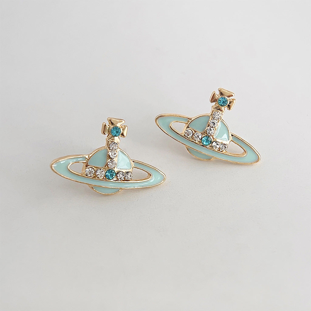 A pair of gold-plated planet stud earrings with light blue enamel and sparkling rhinestone details, part of a five-pair set.