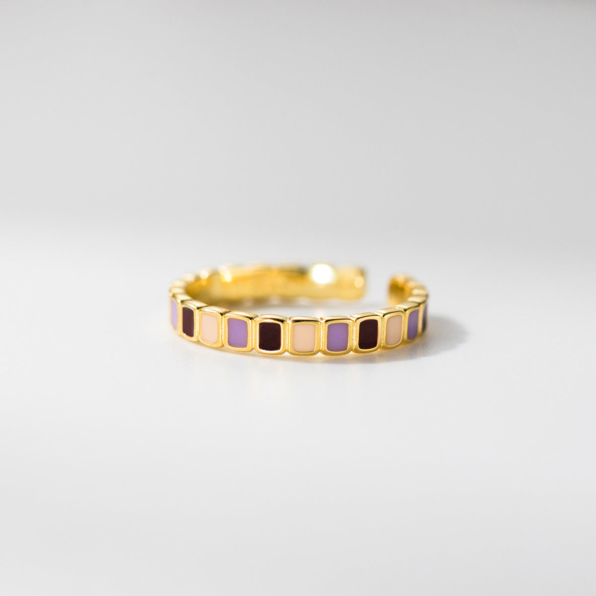 Close-up of a wholesale 925 sterling silver adjustable ring with a gold-plated finish and vibrant color-block enamel inlays in purple, cream, and burgundy.