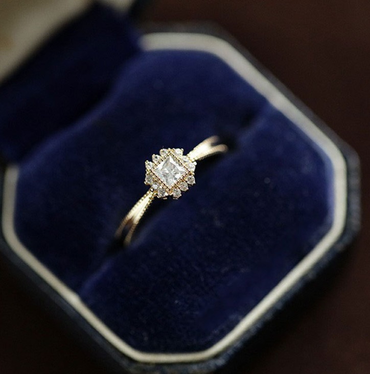 A stunning 925 sterling silver promise ring with a central diamond-like cubic zirconia, elegantly presented in a classic blue velvet ring box.