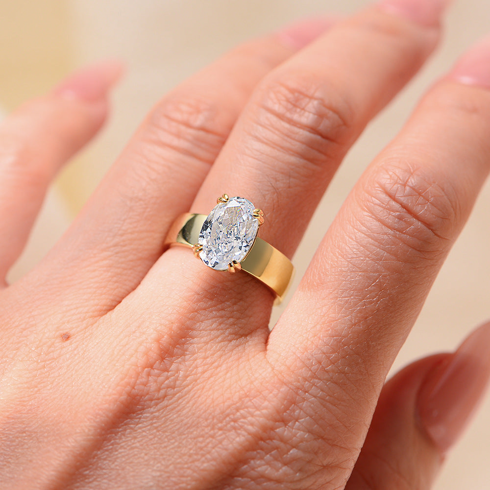 A stunning S925 sterling silver engagement ring with a gold finish, featuring a brilliant oval-cut cubic zirconia centerpiece, inspired by Taylor Swift's style.