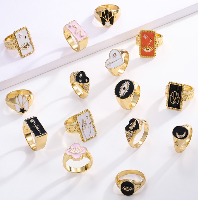 A collection of Tarot Card Enamel Rings by JR Fashion Accessories, showcasing various gold-plated designs with celestial and mystical motifs.