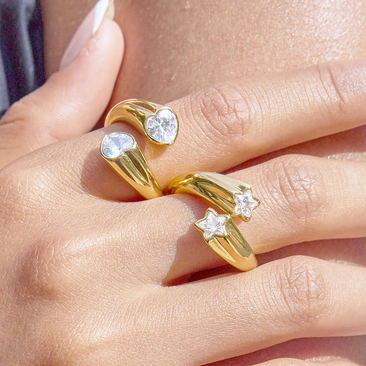 A set of five adjustable gold star rings with sparkling zircon stones, crafted from non-tarnish stainless steel, displayed on a neutral background.