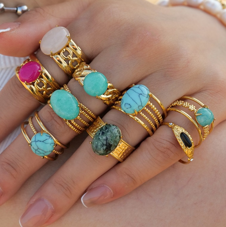A vibrant collection of gold-plated stainless steel rings featuring various colorful natural gemstones, offered wholesale by JR Fashion Accessories.