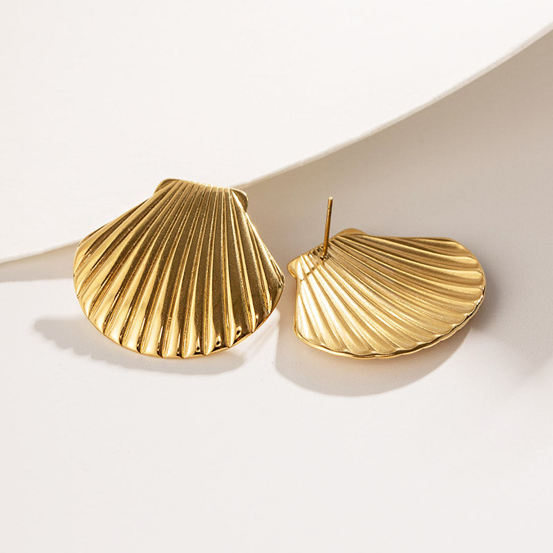 A pair of gold-plated stainless steel chunky shell stud earrings showcasing their detailed ridged design, perfect for beach-themed jewelry.