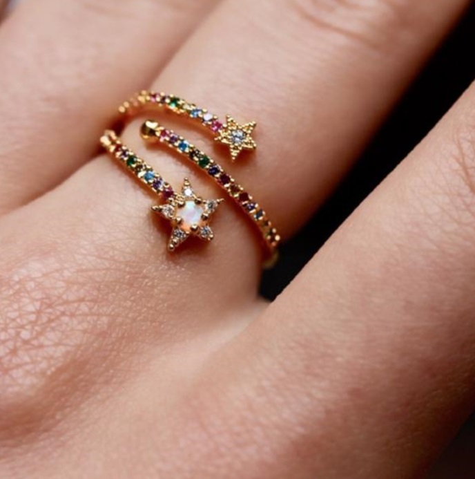 A close-up of the Double Stars Multi Color CZ Ring, showing two gold-plated 925 sterling silver rings with vibrant, multi-colored cubic zirconia stones set in a star design.