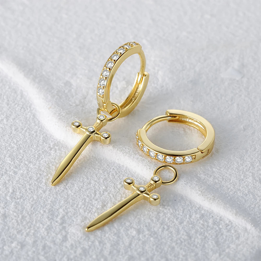 A pair of 925 sterling silver hoop earrings plated in gold, featuring a dangling sword charm embellished with sparkling zirconia stones, on a clean white background.