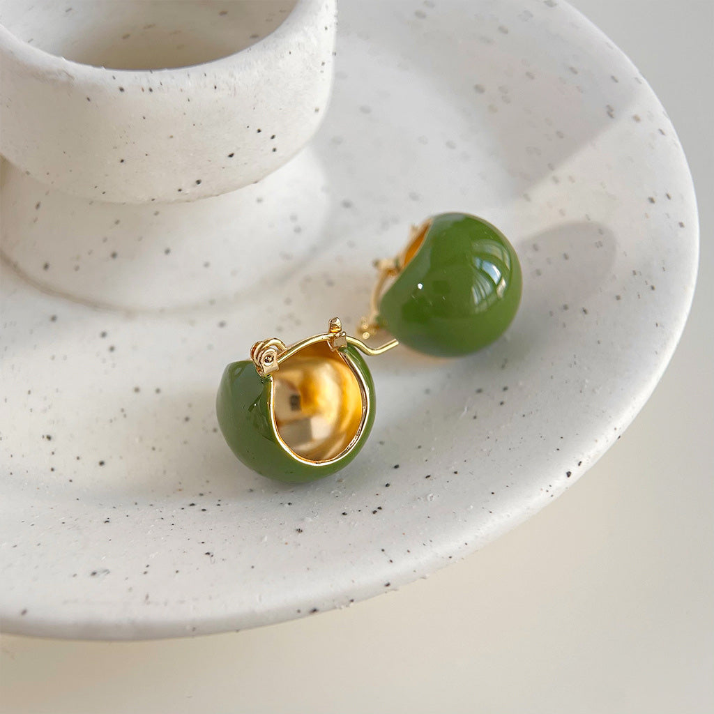 A pair of vintage-style gold-plated hoop earrings with a vibrant green enamel bucket design, displayed on a clean white background.