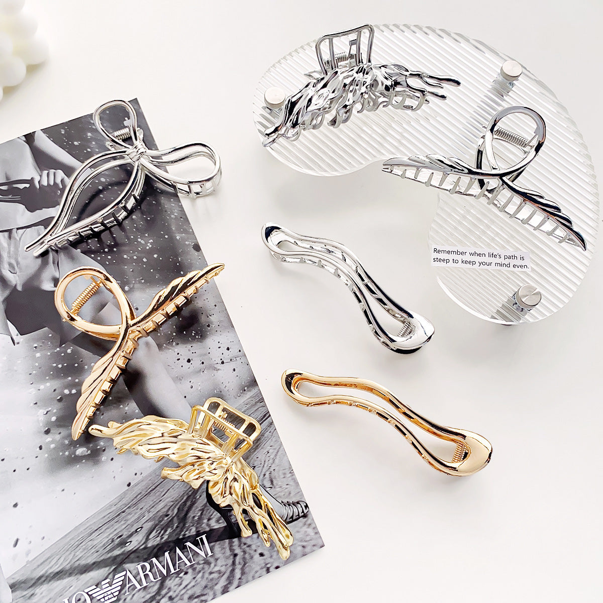 A collection of stylish metal alloy claw hair clips for women, featuring various designs in gold and silver finishes, displayed neatly for a product showcase.