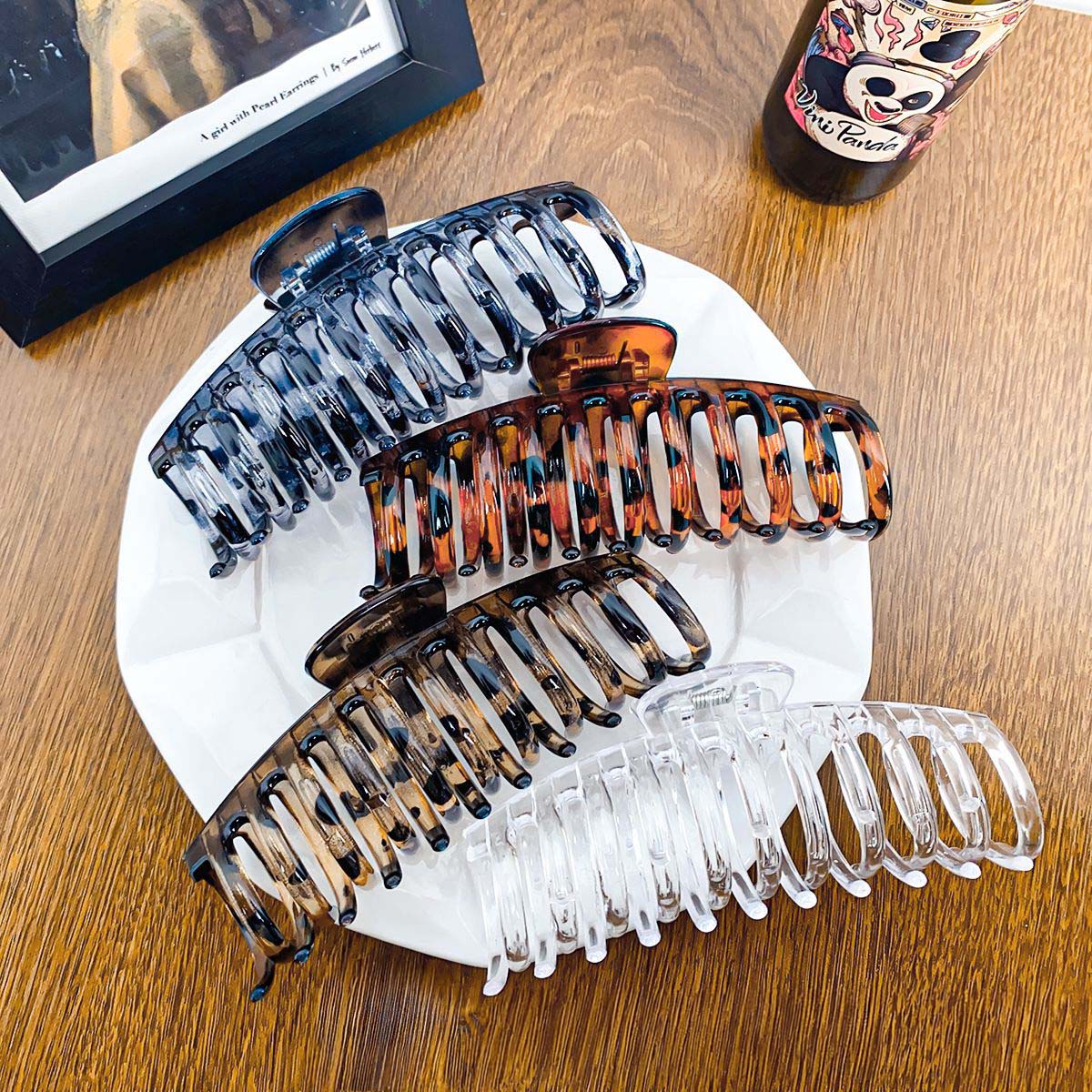 A collection of large hair claw clips in various patterns including tortoise shell, leopard print, black, and transparent, neatly arranged for display.
