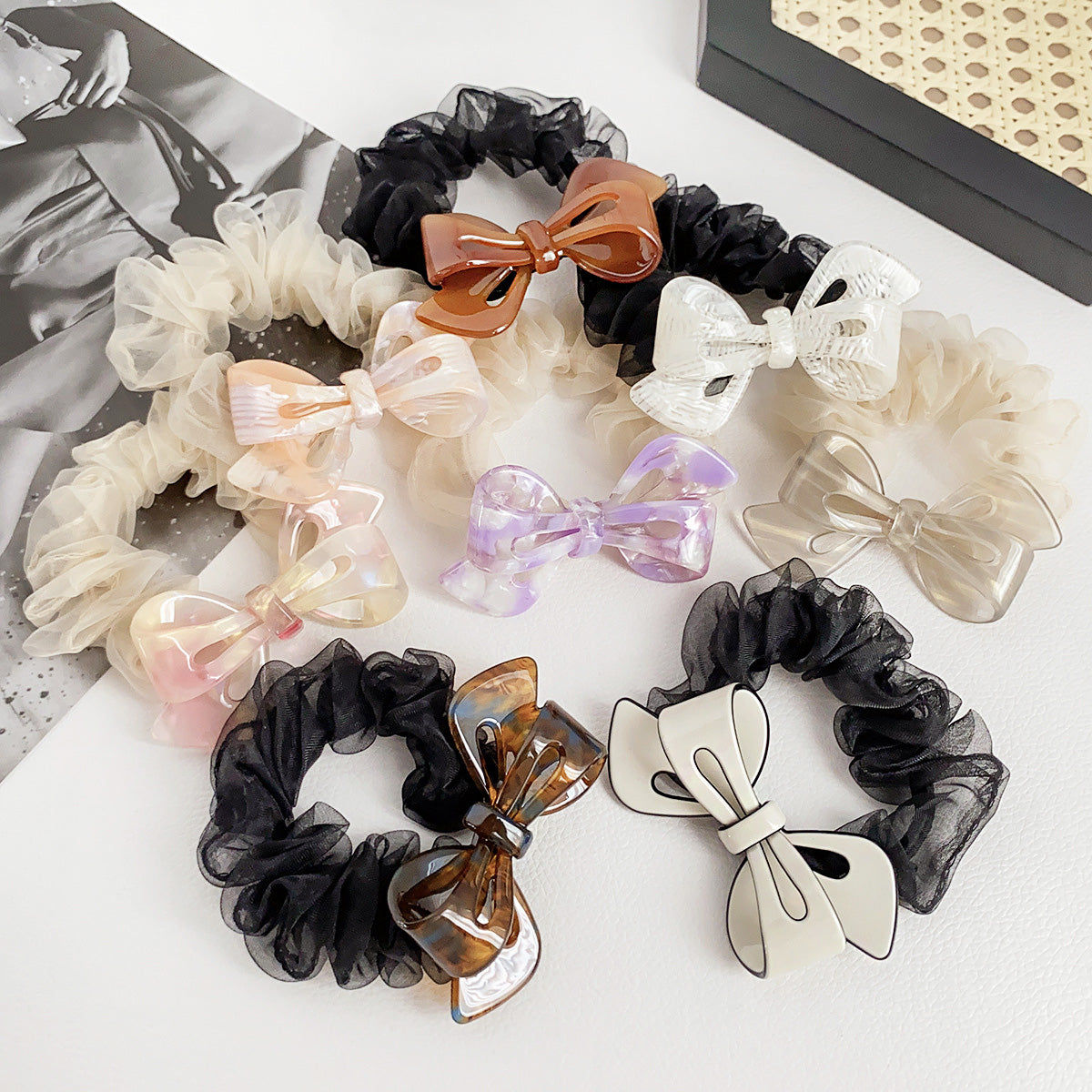 A colorful collection of acetate bow-shaped hair tie scrunchies, showcasing various styles and designs available for sale.