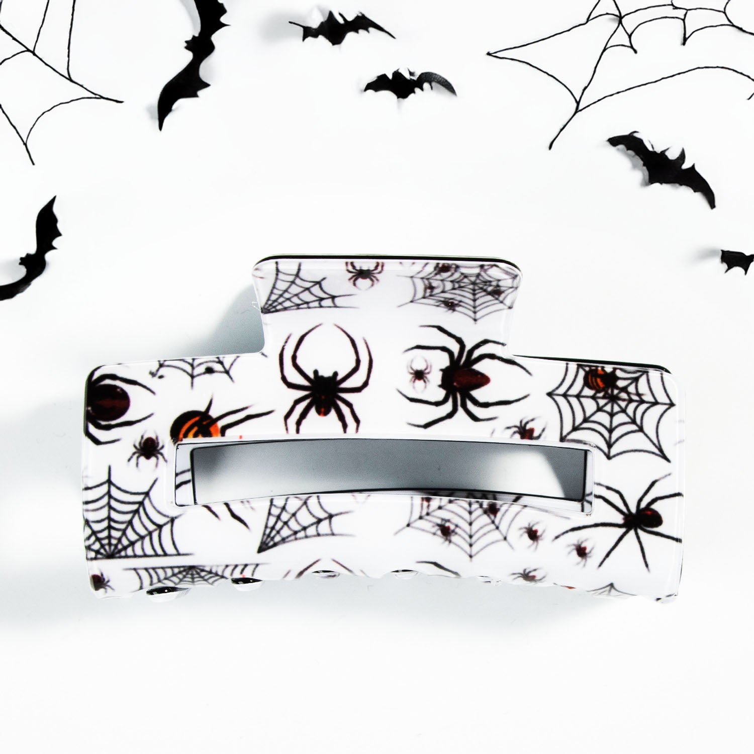 A collection of festive Halloween-themed claw hair clips, featuring designs like pumpkins, ghosts, and spider webs, displayed on a neutral background.