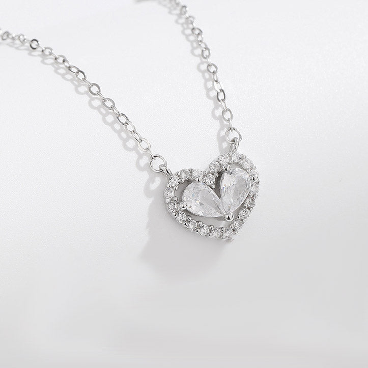 A close-up of a 925 sterling silver heart-shaped choker necklace with a crystal pendant, part of a set of five.