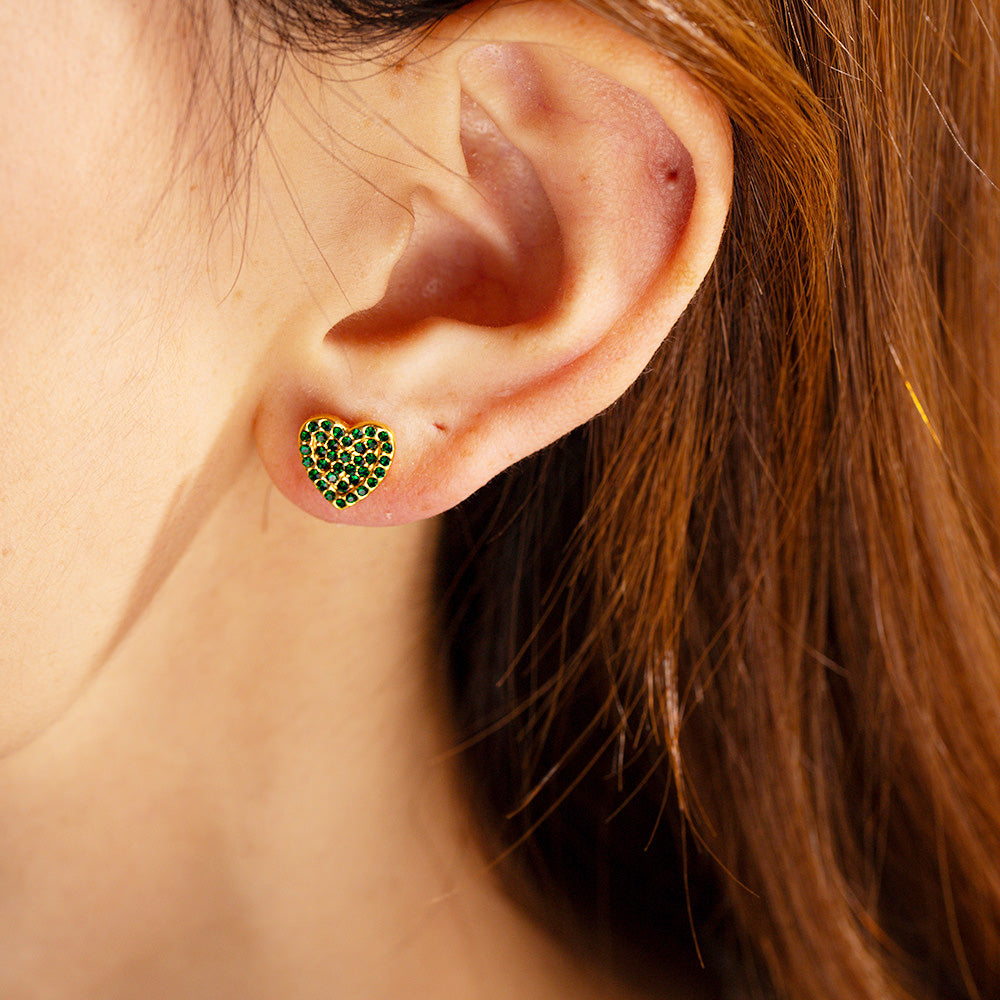 A model showcasing the elegant stainless steel gold pave heart stud earring with a brilliant green zircon stone.