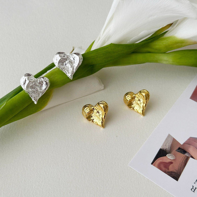 A set of five pairs of metal geometric irregular heart-shaped stud earrings, displayed in both gold and silver finishes on a neutral background.