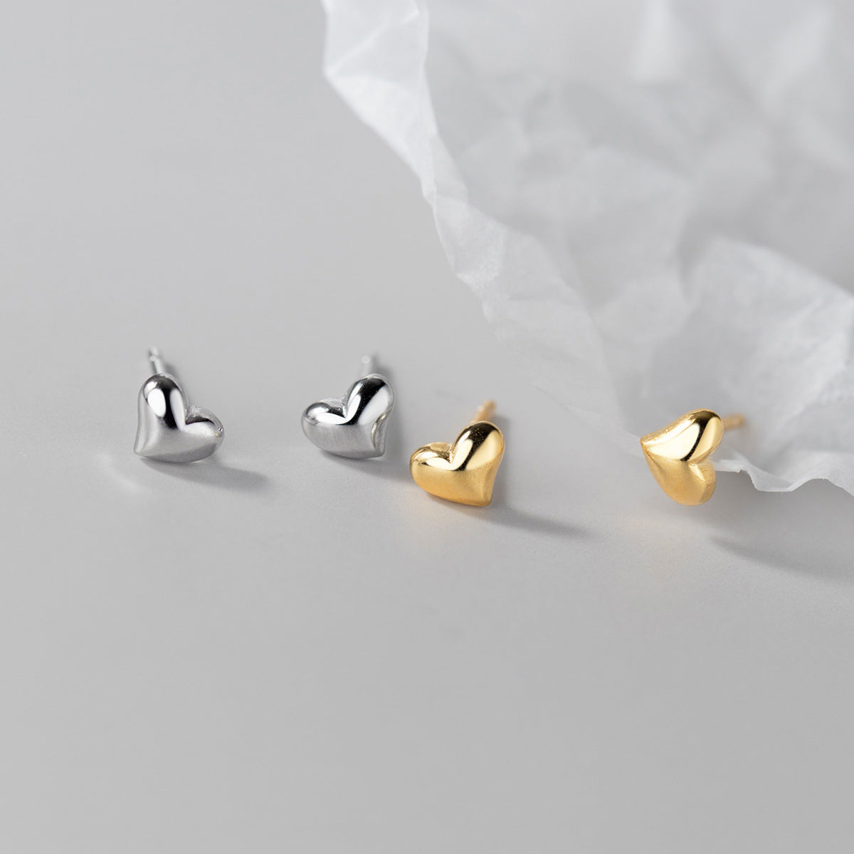 A set of 925 sterling silver tiny mini heart stud earrings, displayed in both silver and gold finishes.