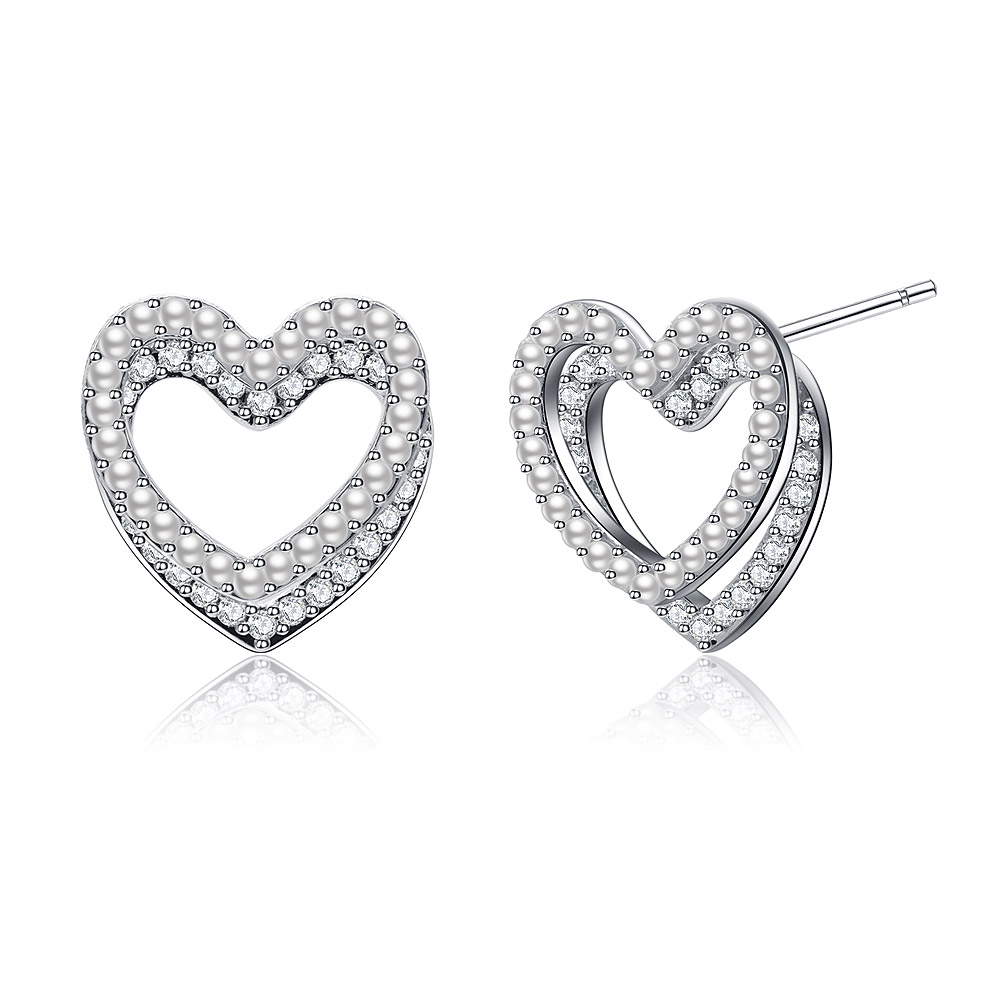 A close-up of the Sweet Double Heart CZ Pearl Stud Earrings, showcasing the intricate double-layered heart design with sparkling cubic zirconia and a central white pearl.