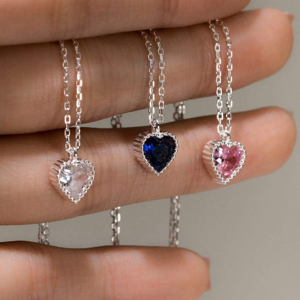 A collection of three 925 sterling silver minimalist heart pendant necklaces with sparkling clear, blue, and pink gemstones.