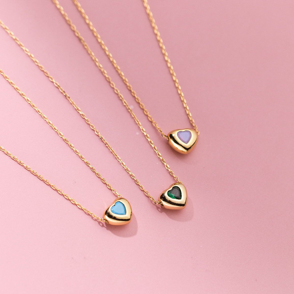 A set of three 925 sterling silver heart pendant necklaces with assorted colored gemstones, available for wholesale from JR Fashion Accessories.