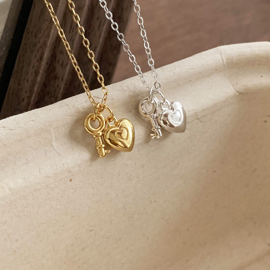 A wholesale set of 925 sterling silver mini heart key pendant necklaces, displaying both the elegant gold and classic silver options side-by-side.