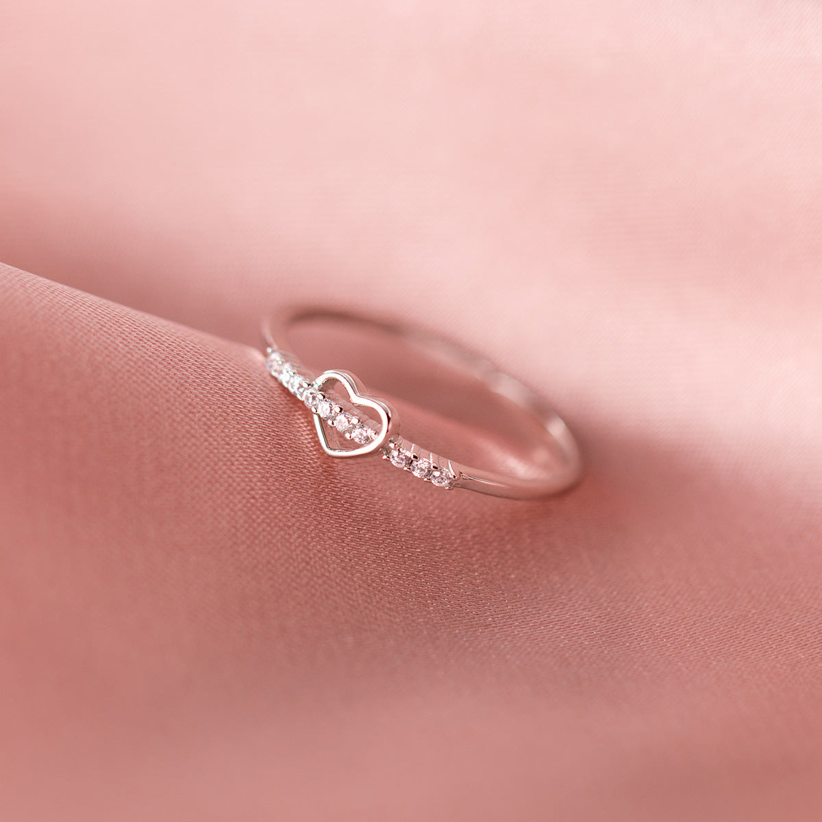 A close-up of a beautiful 925 sterling silver adjustable heart ring with delicate gemstones, part of a set of five.