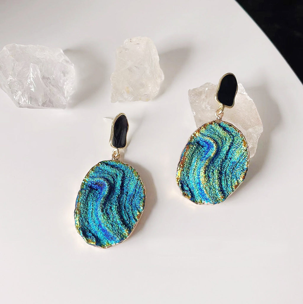 A pair of 14k gold-plated drop earrings featuring a unique and colorful Klein blue starry-sky texture, set against a clean white background.